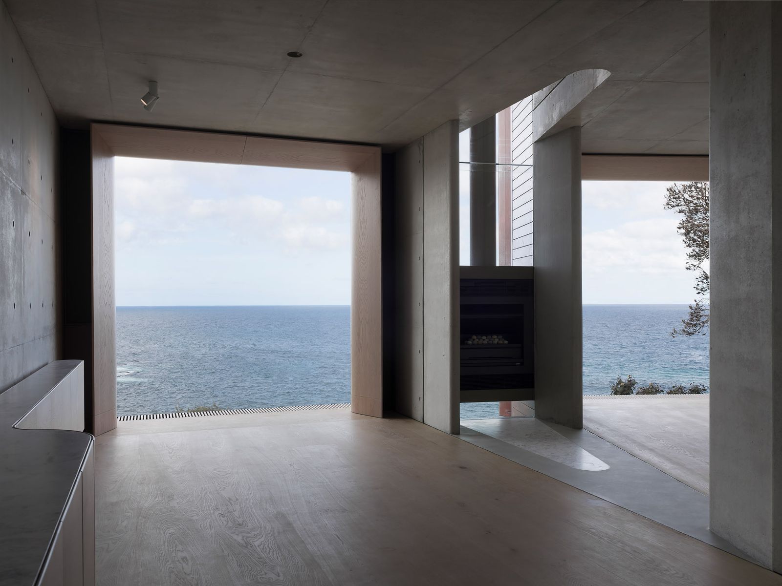 Off-form concrete home against a coastal sky